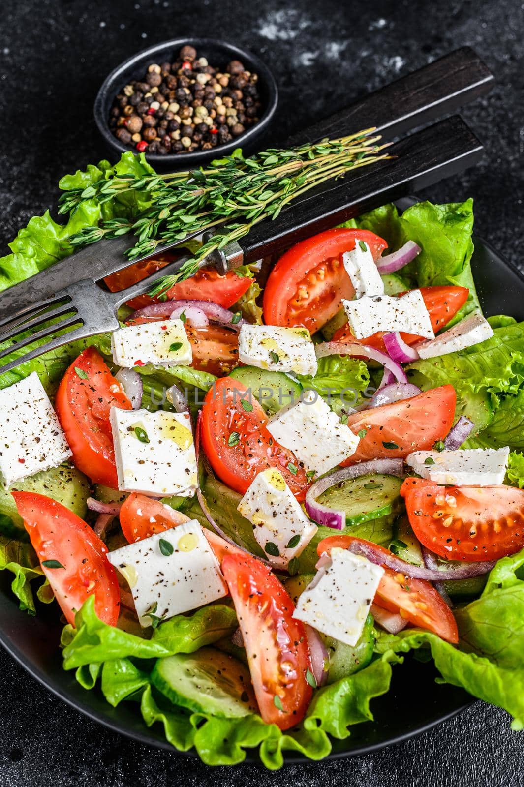 Bowl of ready-to-eat Greek salad. Black background. Top view by Composter