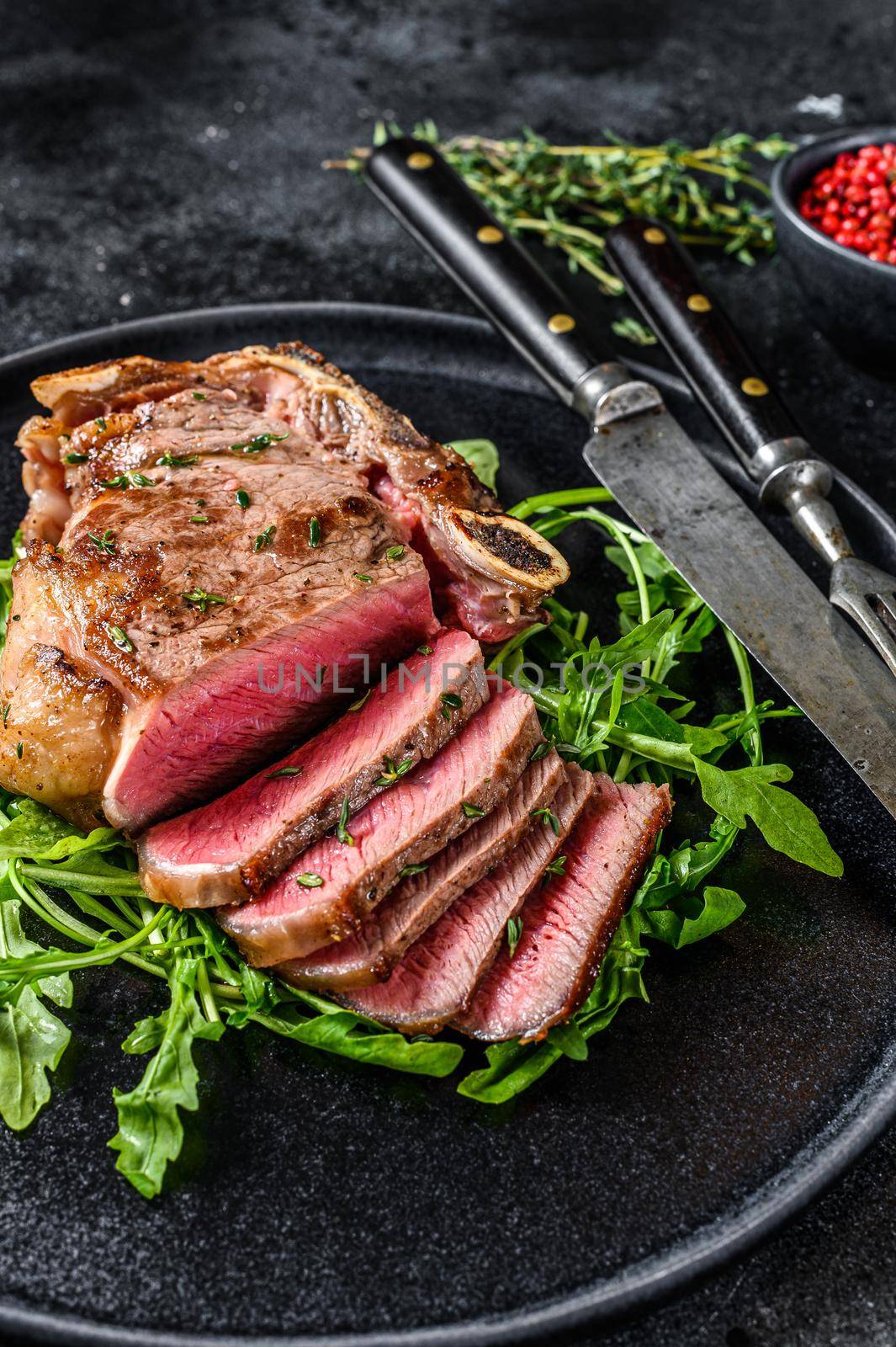 Rare sliced grilled club beef meat steak. Black background. Top view by Composter