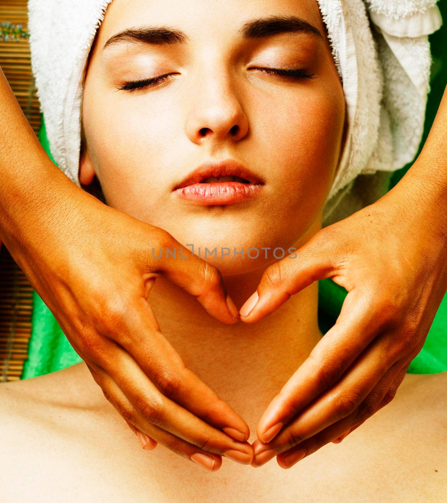 Attractive lady getting spa treatment in salon, closeup asian tan hands on face