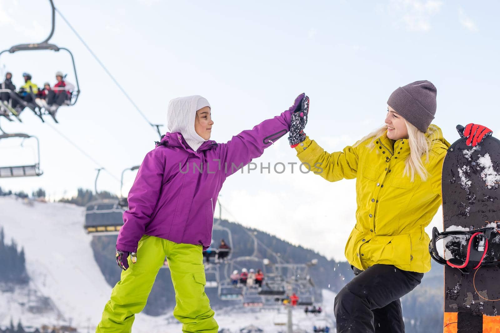 Mother and daughter with snowboards are playing in the snow by Andelov13