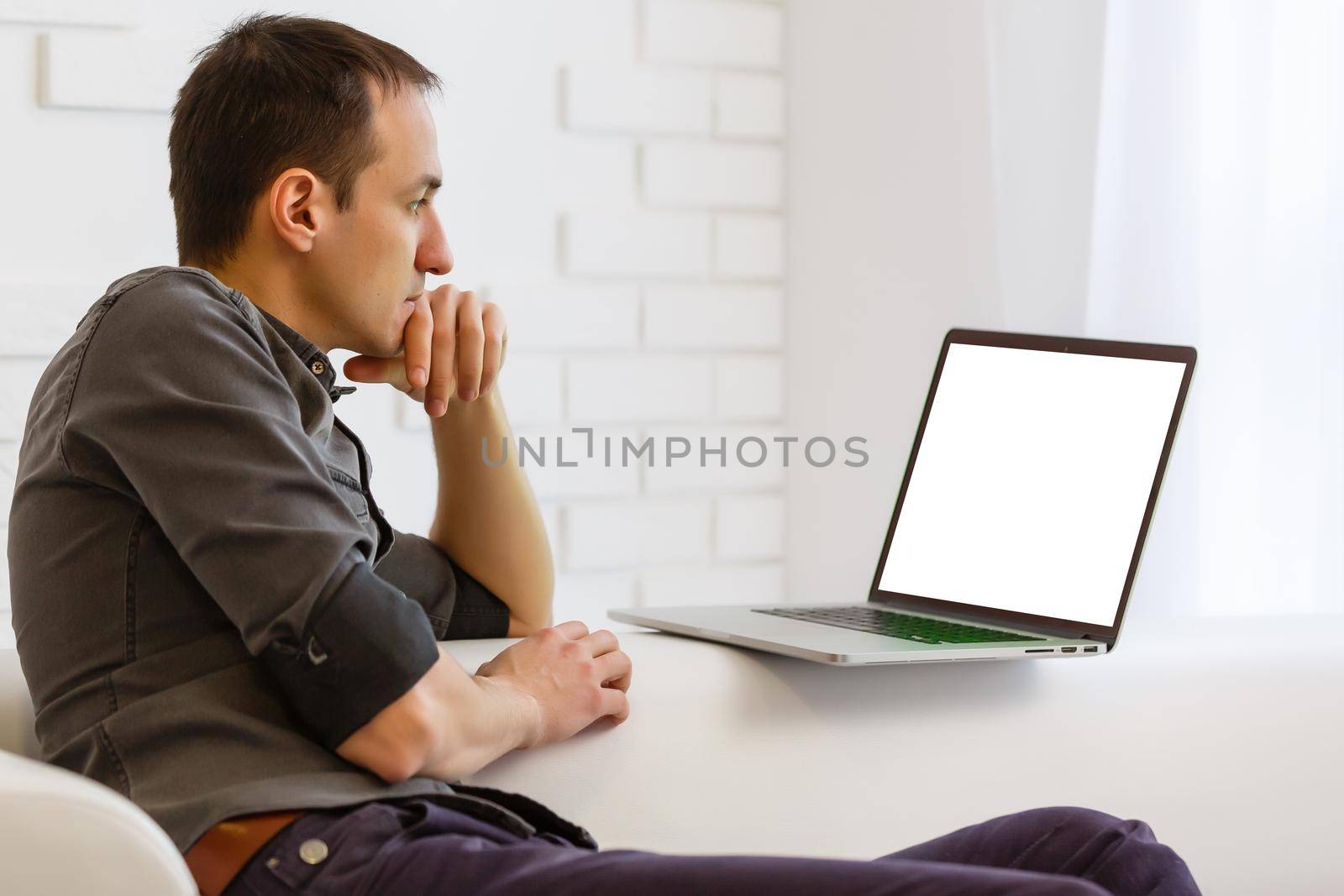 Back view of male person sitting front open laptop computer with blank empty screen for your information or content, modern businessman working in internet via notebook,student at coffee shop learning