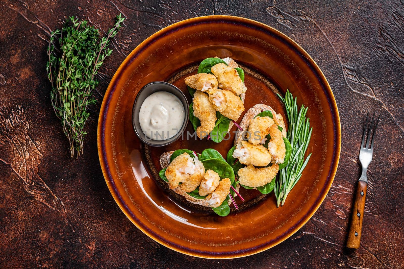 Sandwichs with Fried Shrimps, Prawns, spinach and chard salad on a rustic plate. Dark background. Top view by Composter