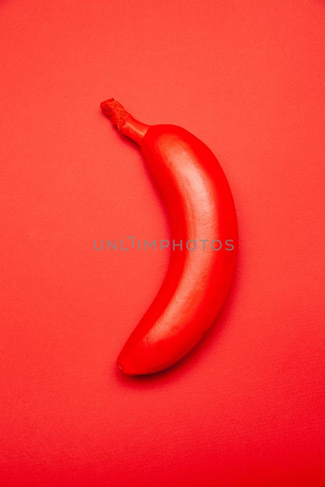 Red colored tropical banana on bright surface by Julenochek