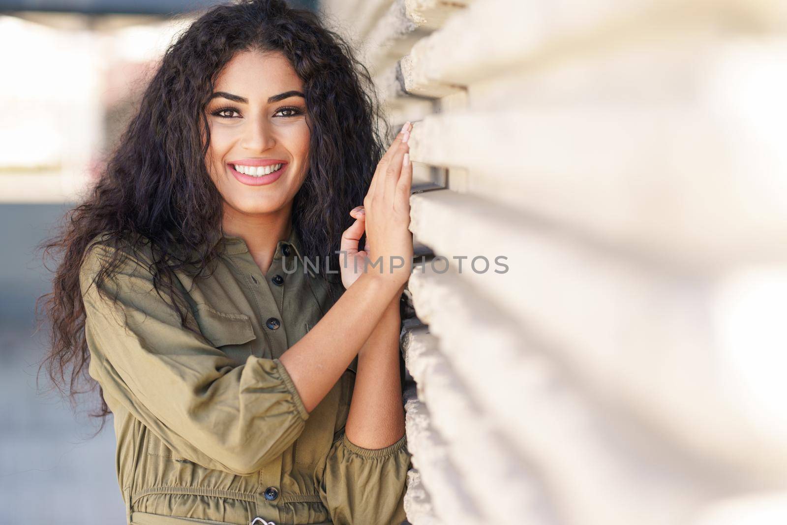 Young Arab Woman with curly hair smiling outdoors