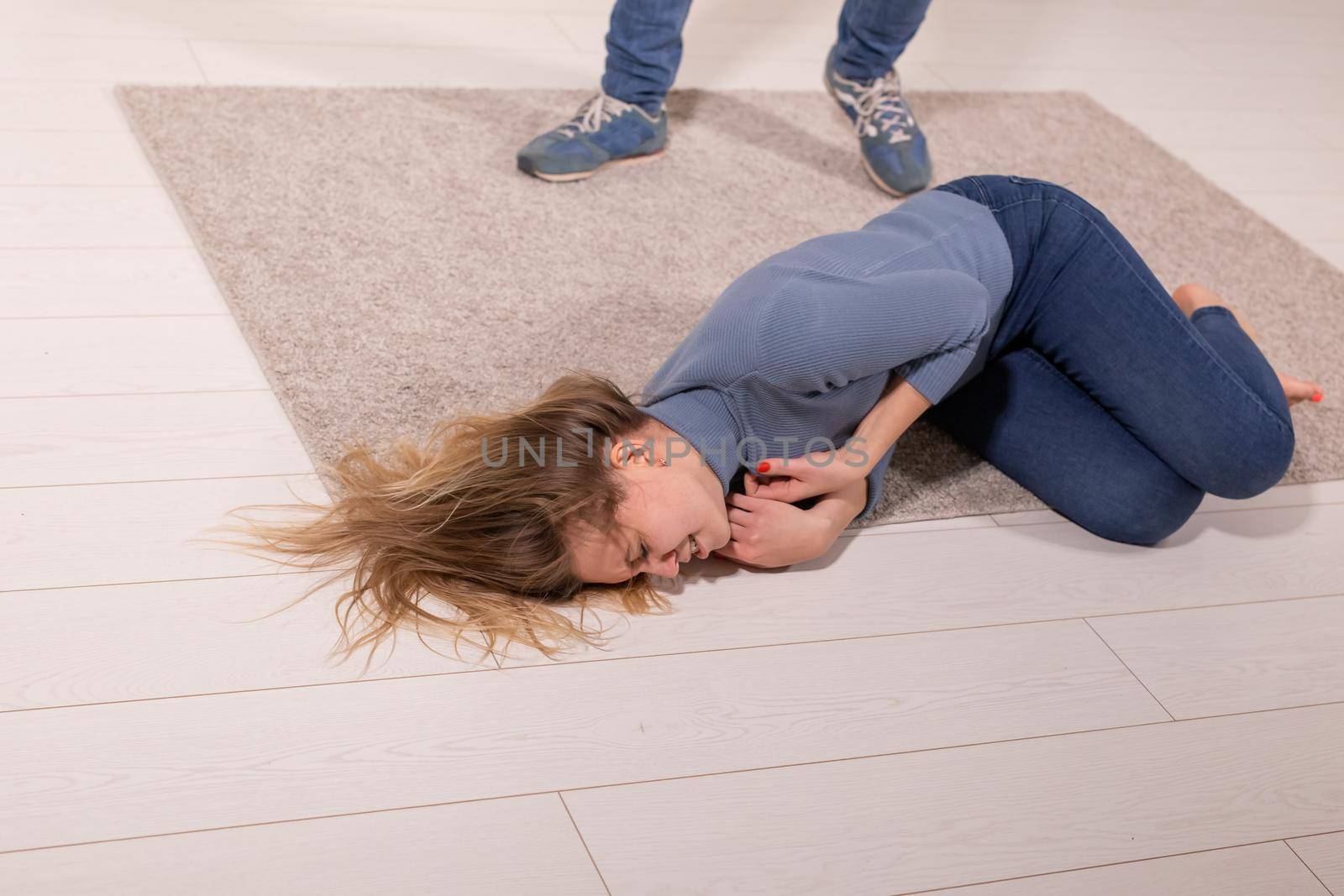 people, abuse and violence concept - woman threatened by husband lying on floor.