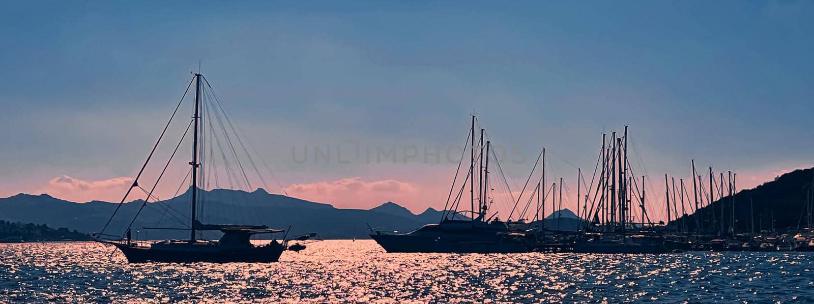 Tranquil seascape and coastal nature concept. Sea, boats, mountains and blue sky over horizon at sunset by Anneleven
