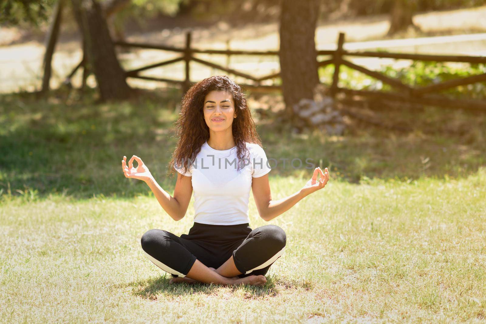 Young Arab woman doing yoga in nature by javiindy