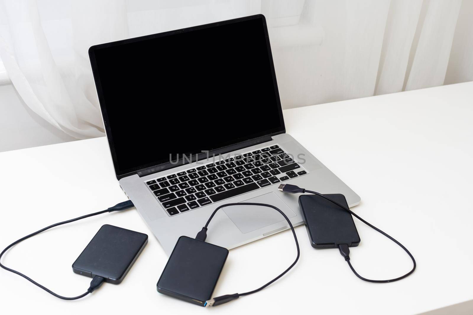 External backup disk hard drive connected to laptop. High quality photo
