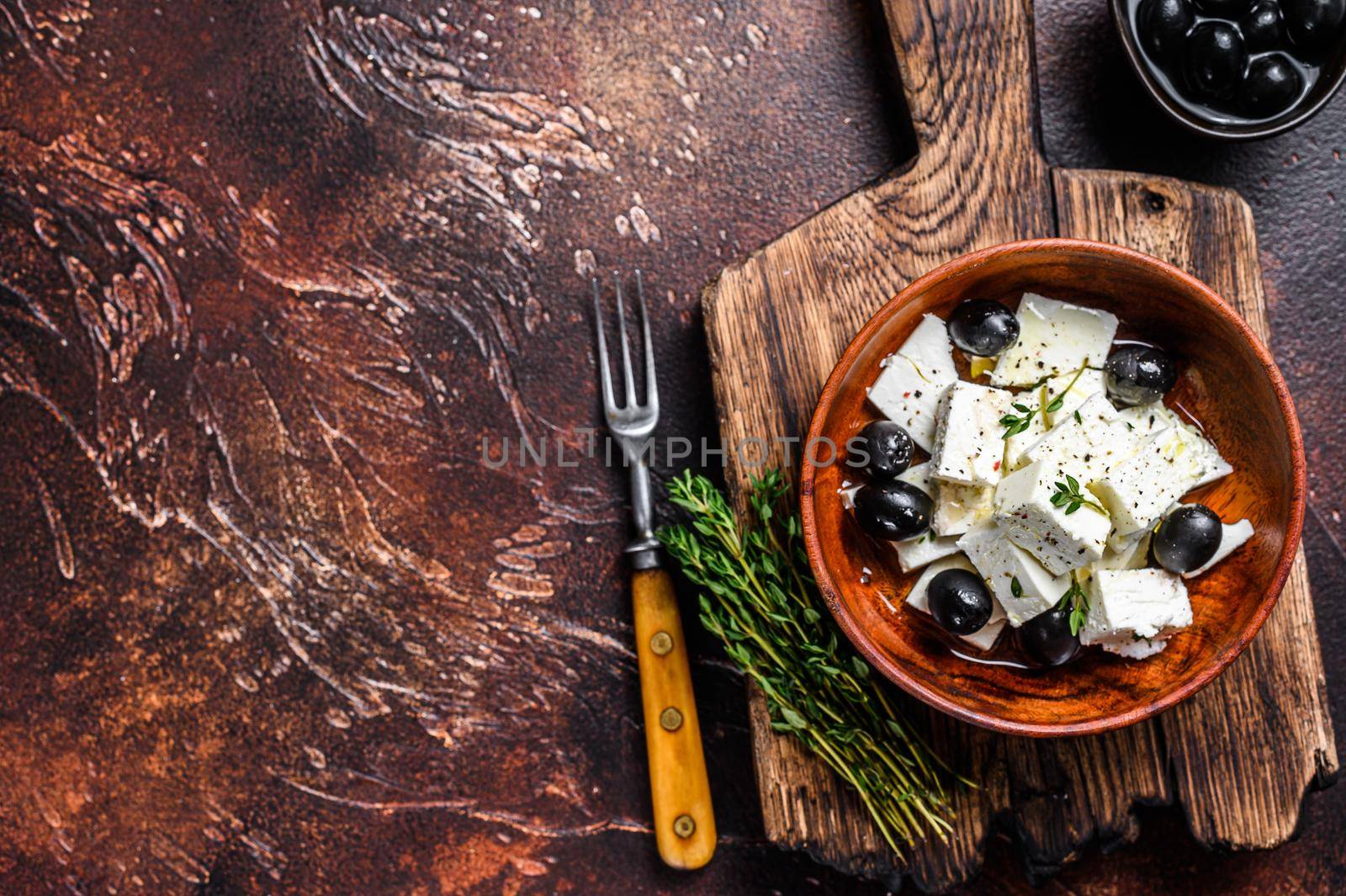 Salad with fresh feta cheese, thyme and olives. Dark background. Top view. Copy space.