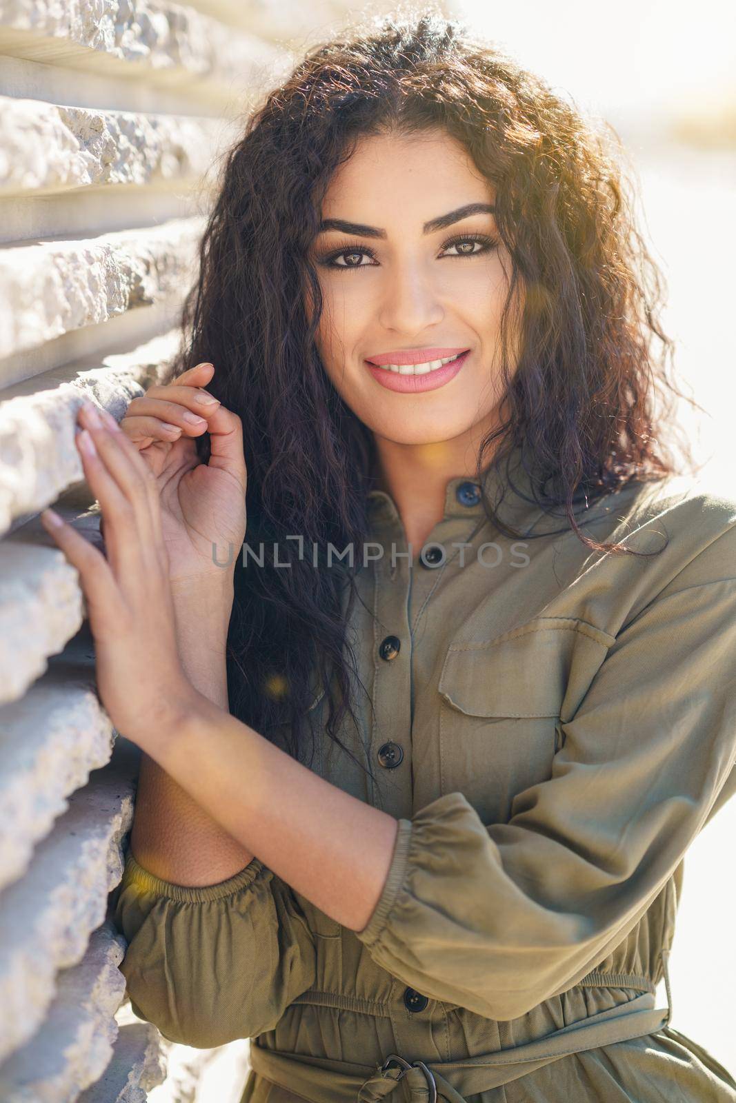 Smiling Arab Woman with curly hair in urban background