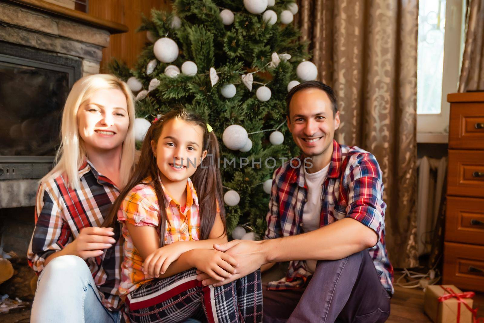 Family in an old wooden house. Beautiful christmas decorations. The festive mood. Christmas holidays. by Andelov13