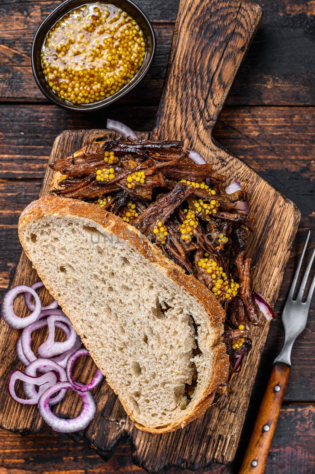 BBQ Sandwich with slow roasted pulled pork meat. Dark wooden background. Top view by Composter