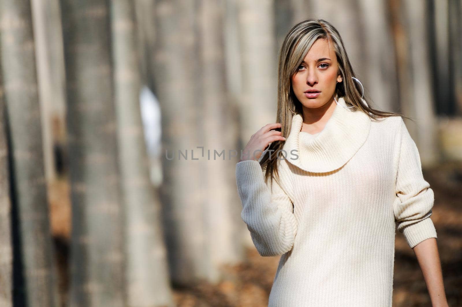 Beautiful blonde girl, dressed with a beige dress, standing in a poplar forest by javiindy