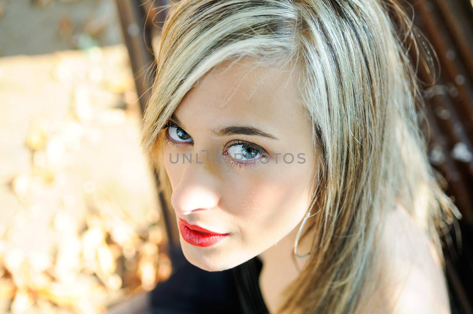 Pretty girl sitting in a bench in the park by javiindy