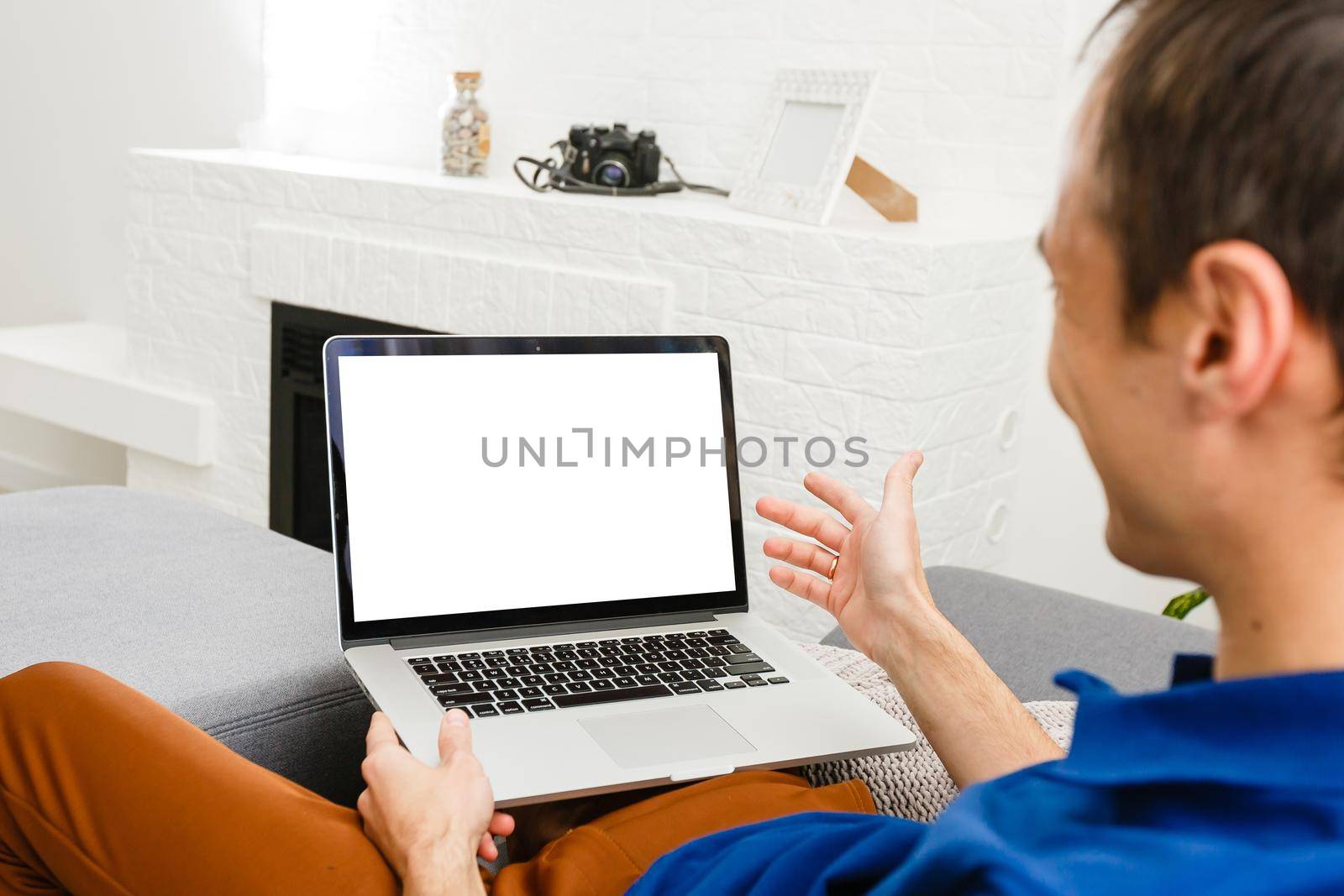 Back view of male person sitting front open laptop computer with blank empty screen for your information or content, modern businessman working in internet