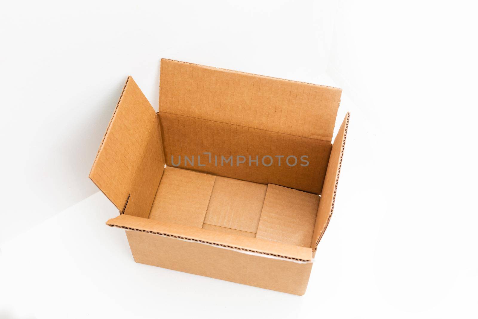 open big empty brown square cardboard box for transporting goods on white background, by Andelov13