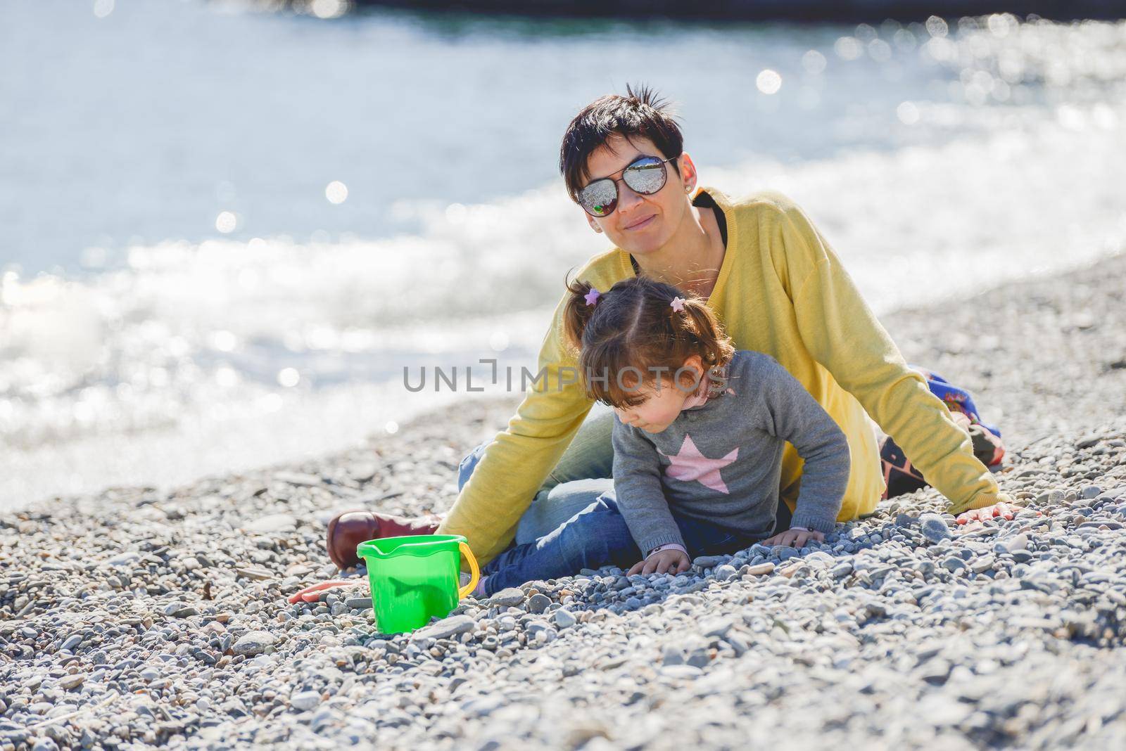 Mother and daughter having fun on the beach by javiindy