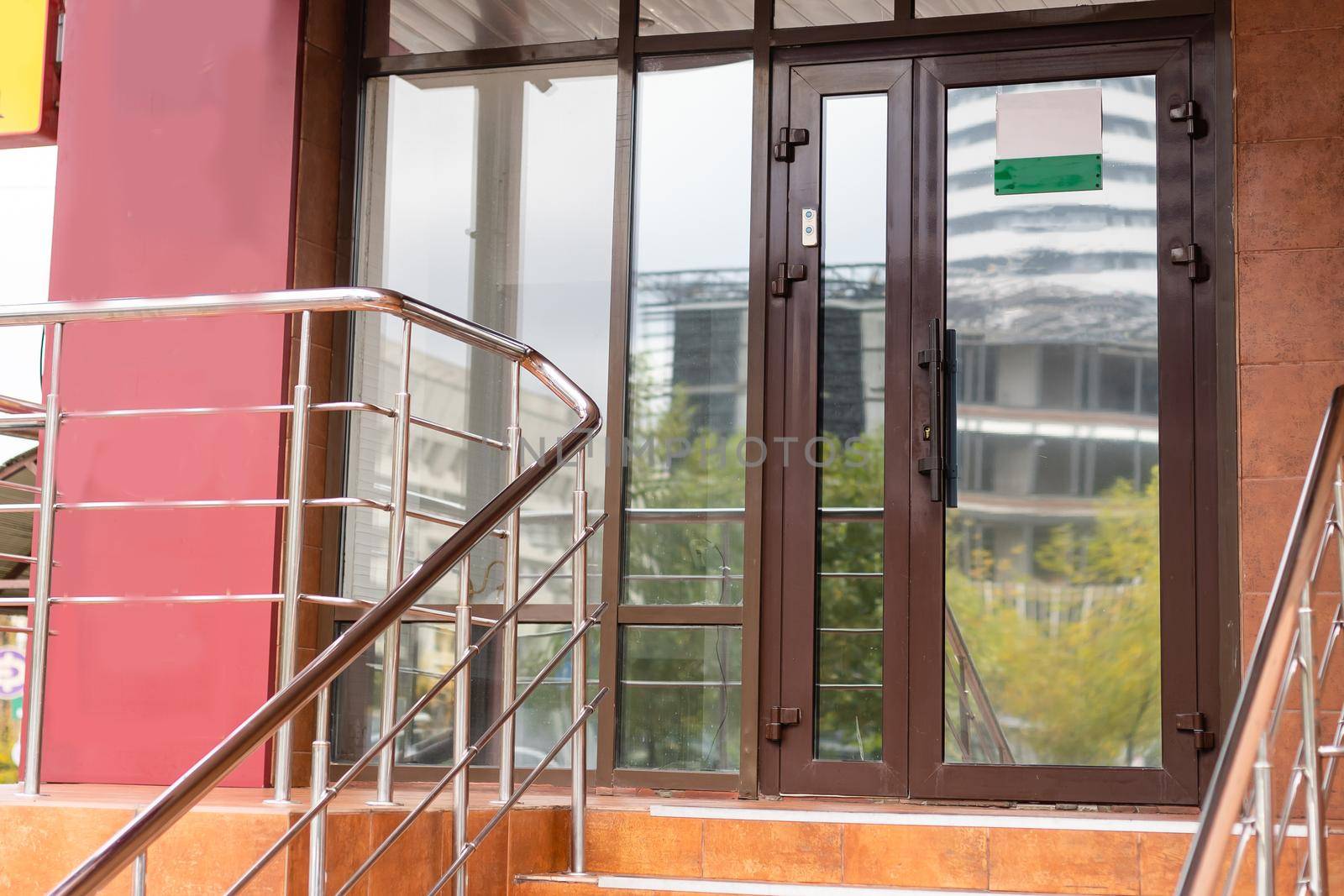 The front door of a office block, reflecting buildings in the glass.