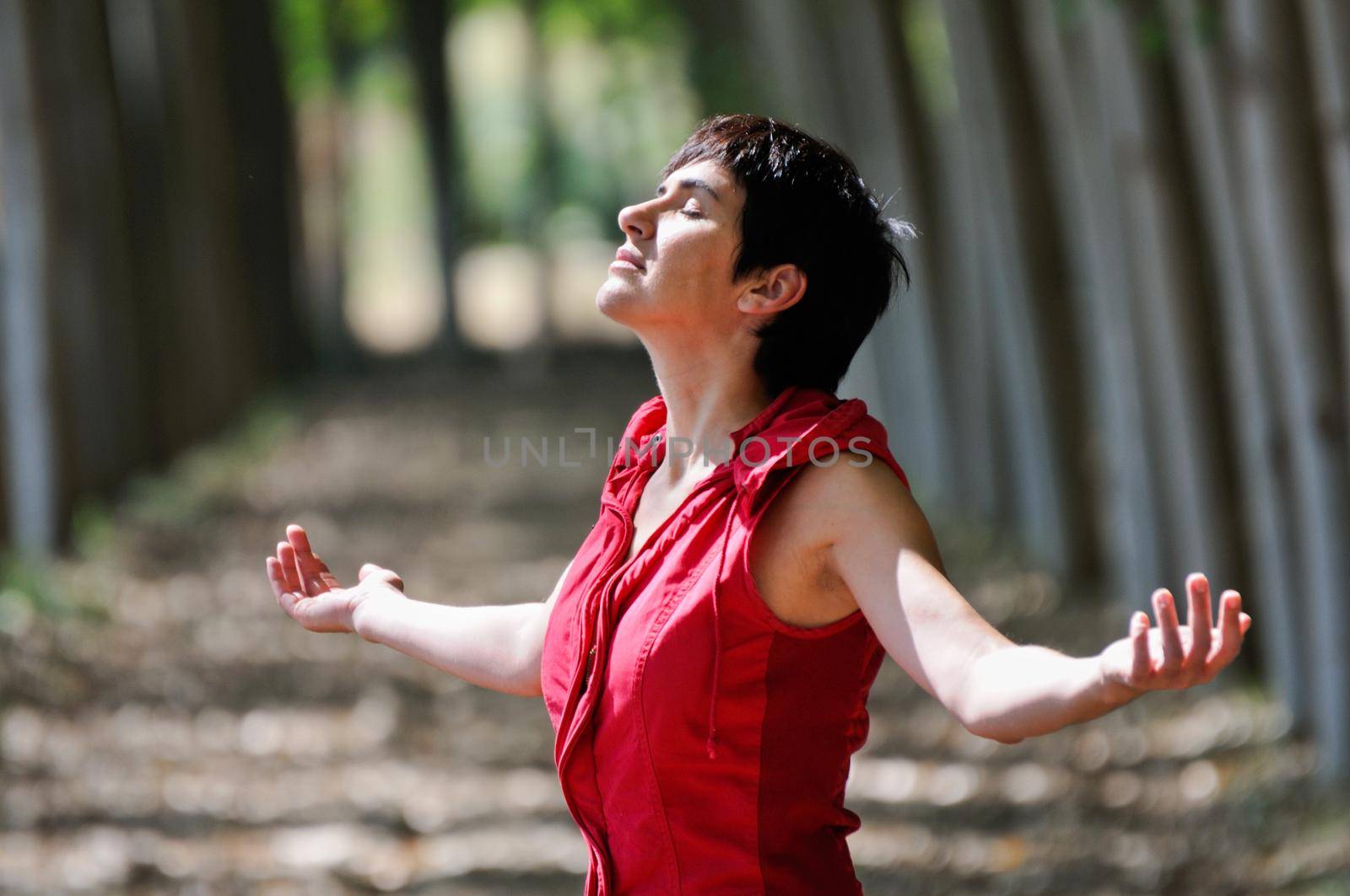 Woman dressed in red, meditating in the forest by javiindy