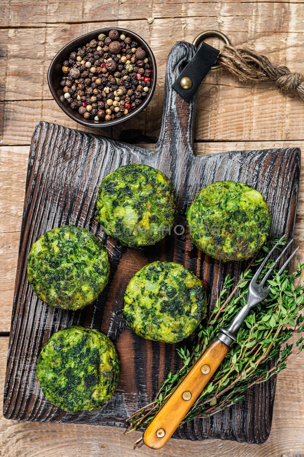 Vegetarian vegetable burgers patty with herbs on wooden board. Wooden background. Top view.