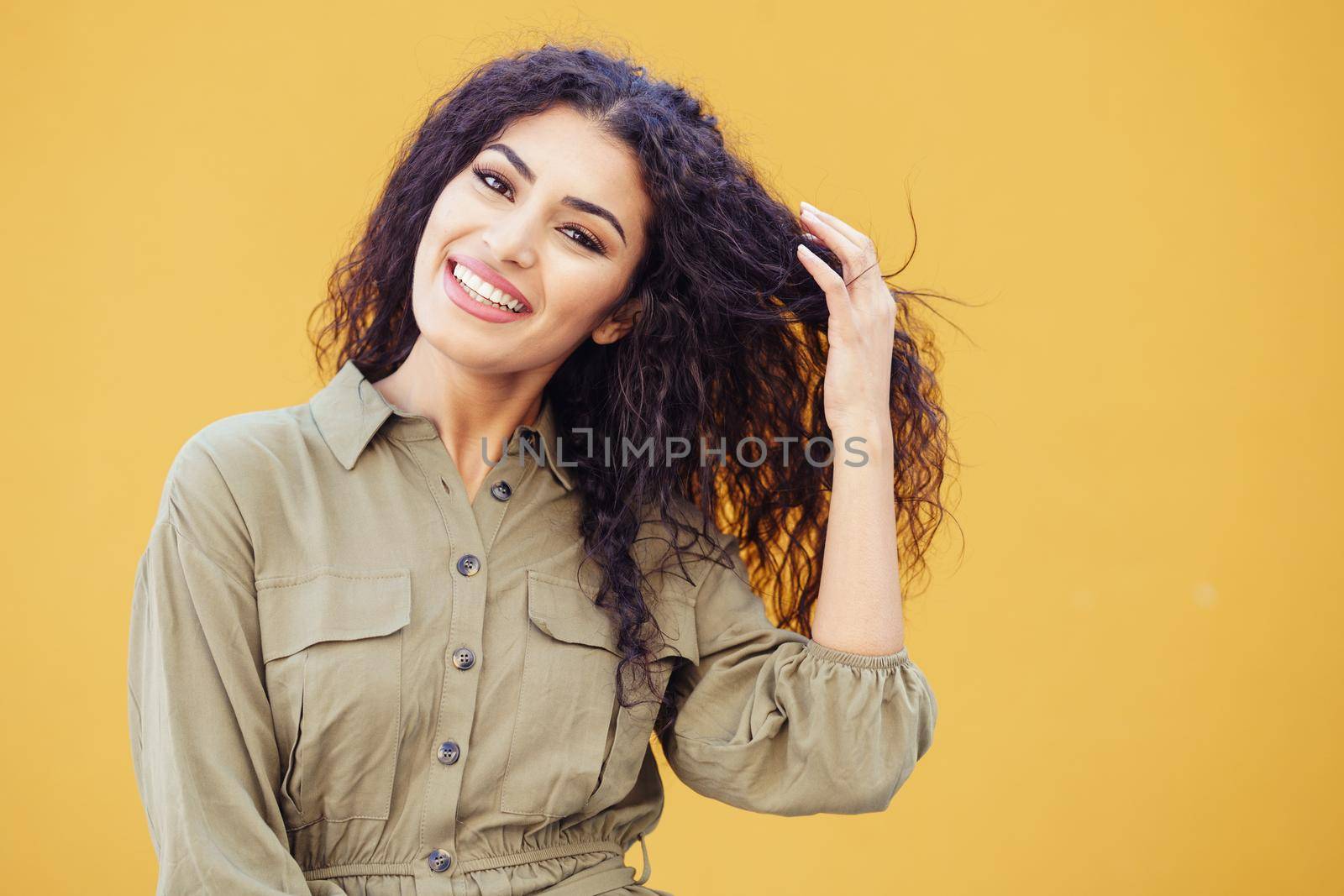 Happy Arab Woman with curly hair in urban background
