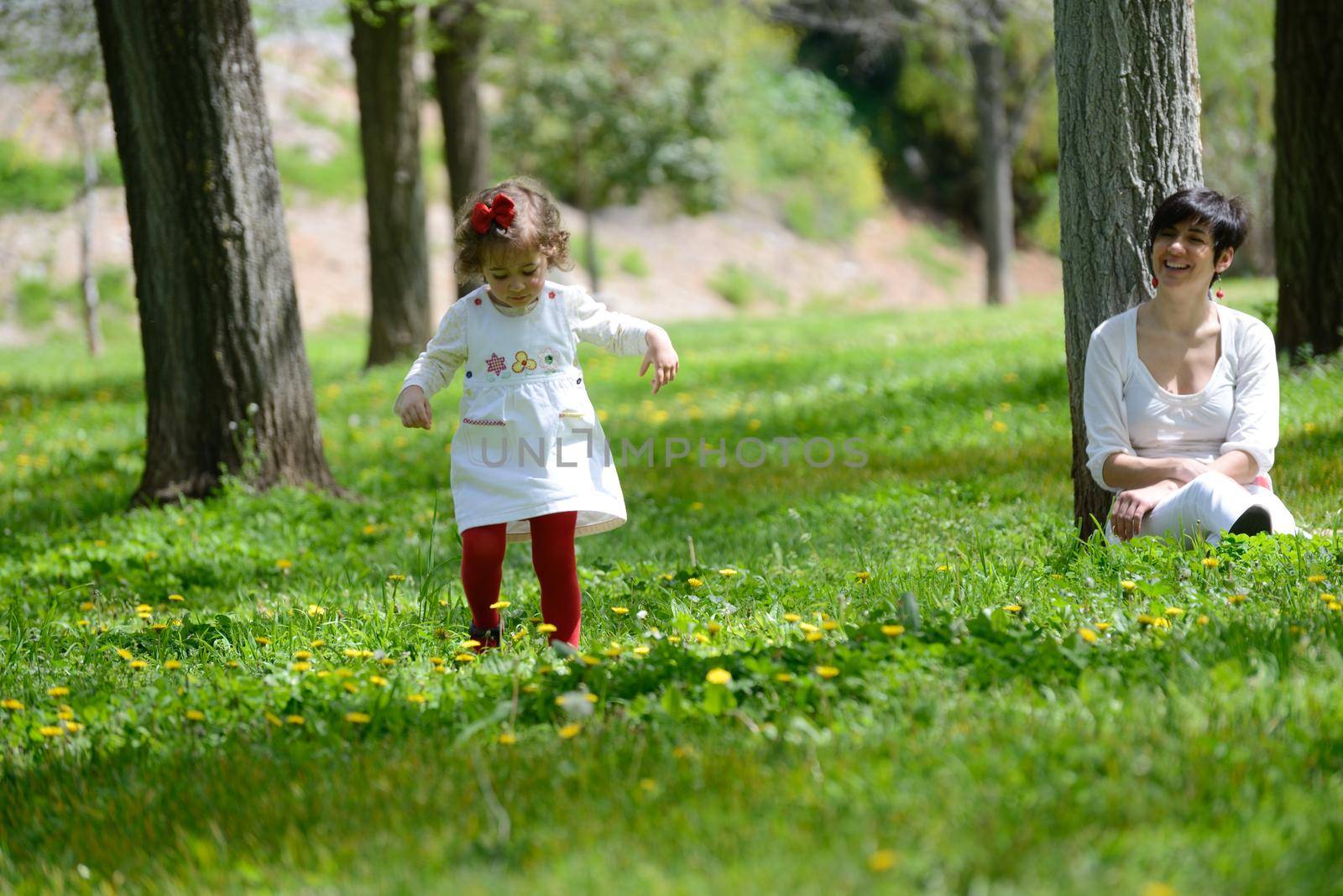 Mother and little girl playing in the park by javiindy