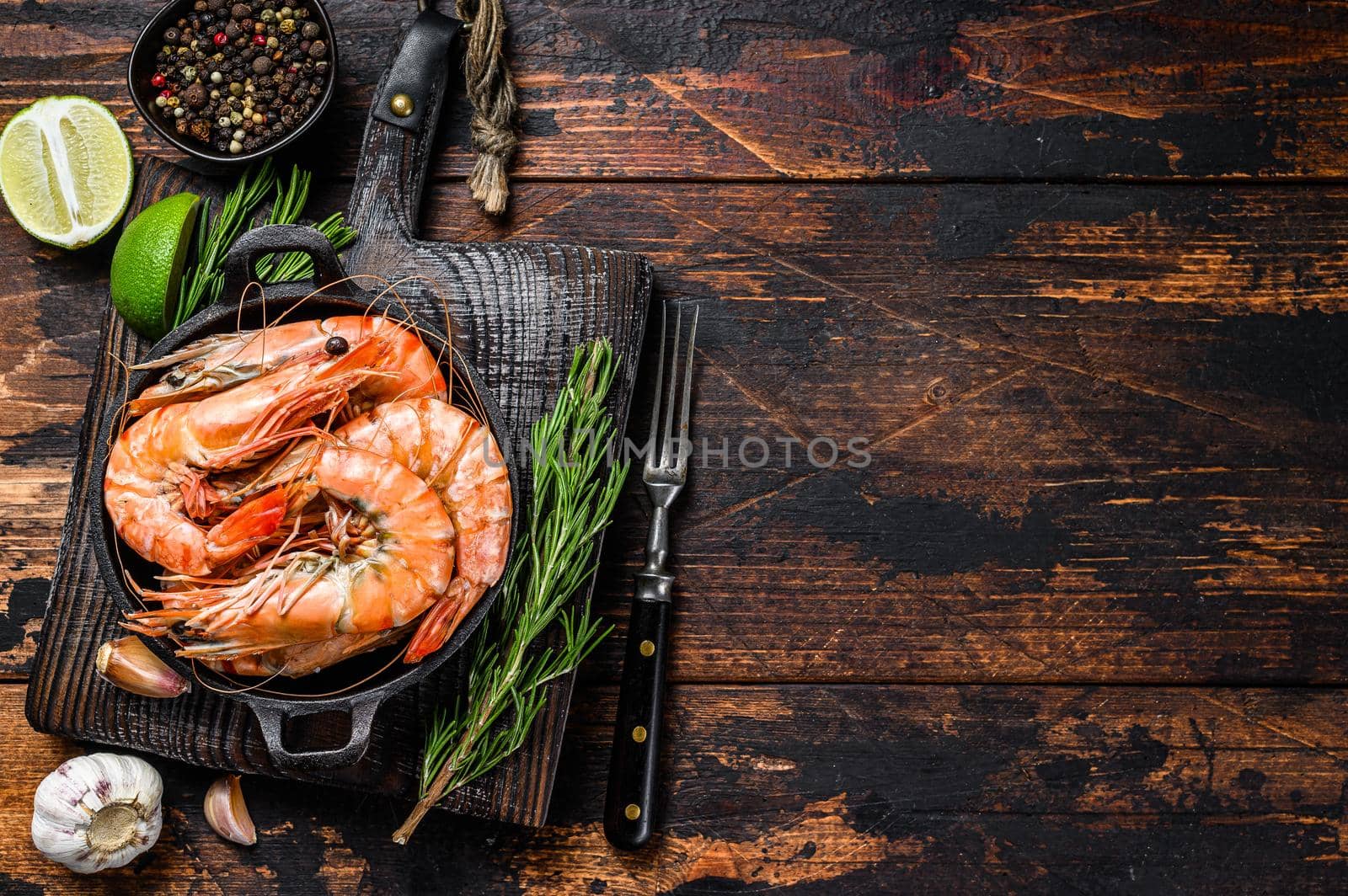 Red Tiger shrimps Prawns in a pan. Dark wooden background. Top view. Copy space by Composter