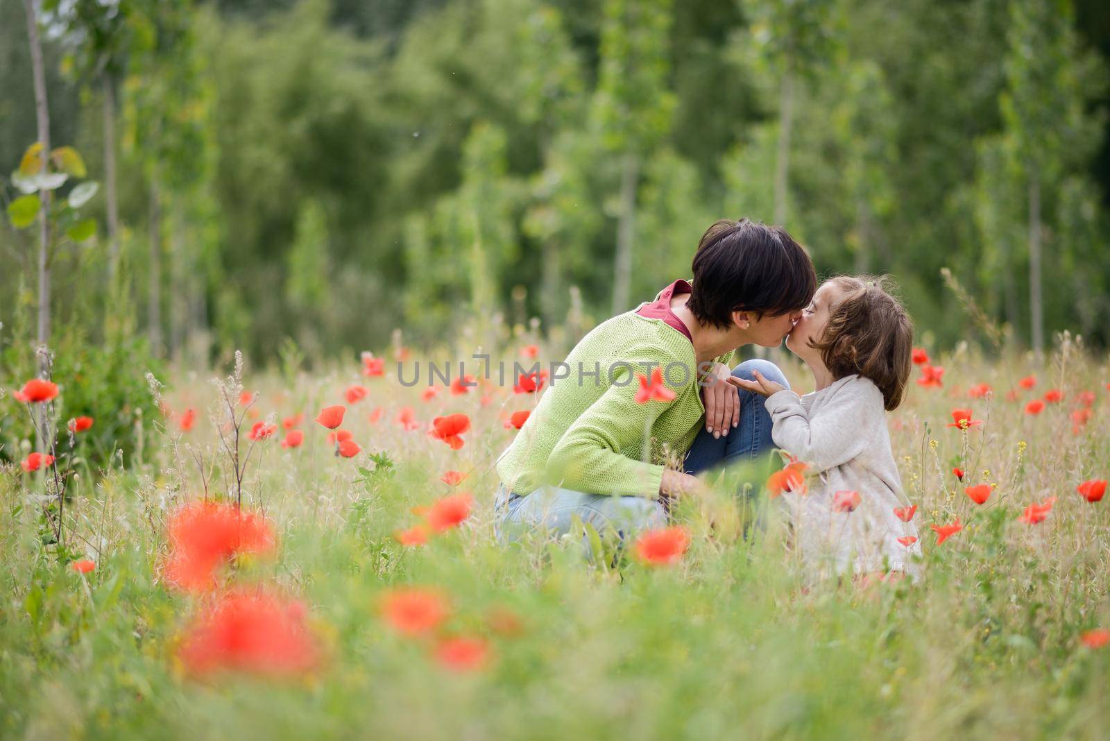 Mother with her little daughter in poppy field by javiindy