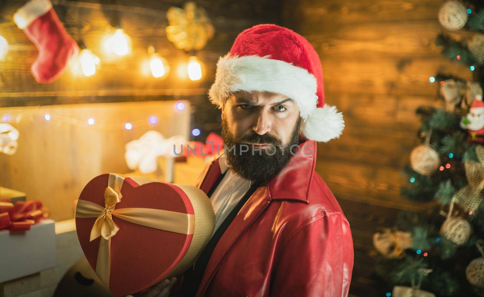 Santa man with Christmas gifts. New year gift box. Bearded modern santa wishes Merry christmas and Happy new year