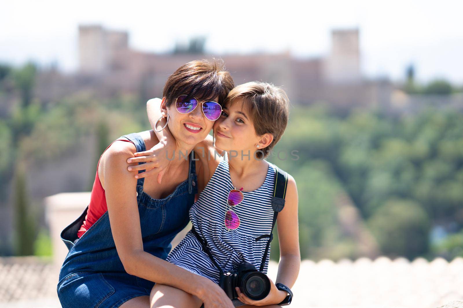 Mother and her little daughter traveling together in Granada, Andalusia, Spain with the Alhambra in the background