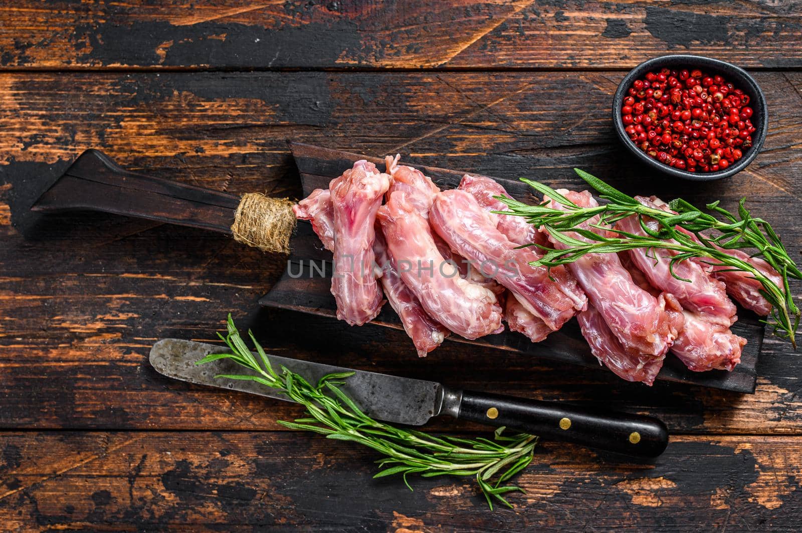 Chicken neck meat on a cutting board. Wooden background. Top view by Composter