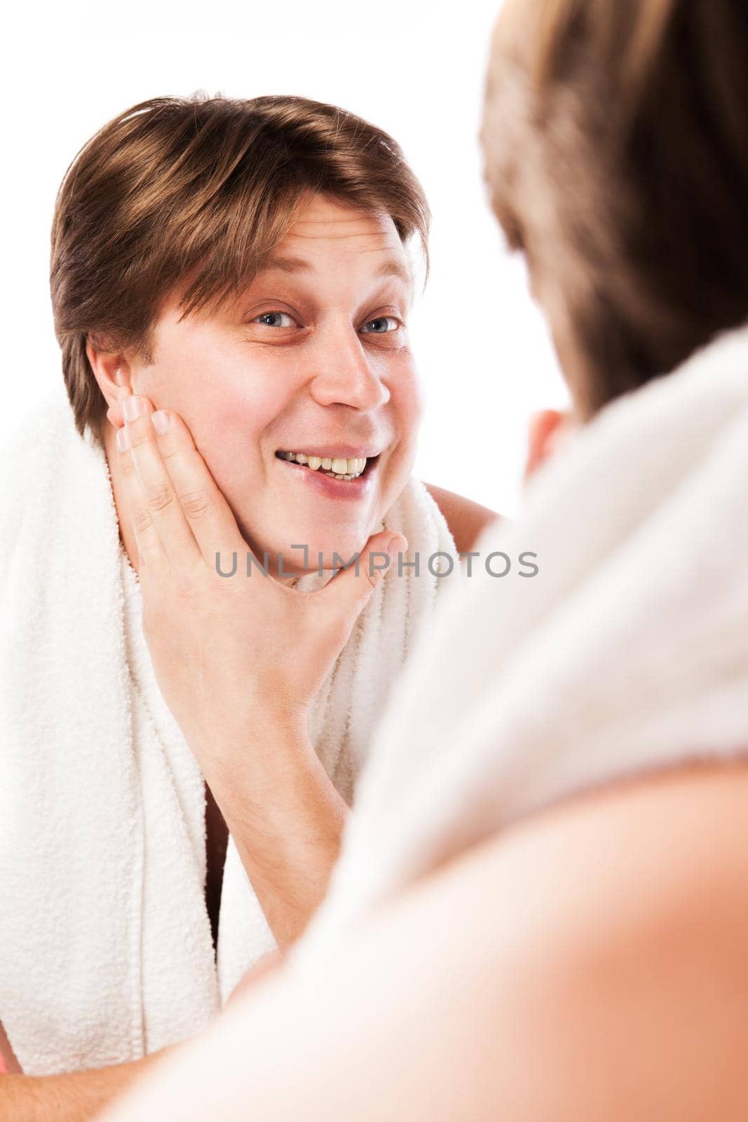 Man examining his stubble in mirror isolated over white