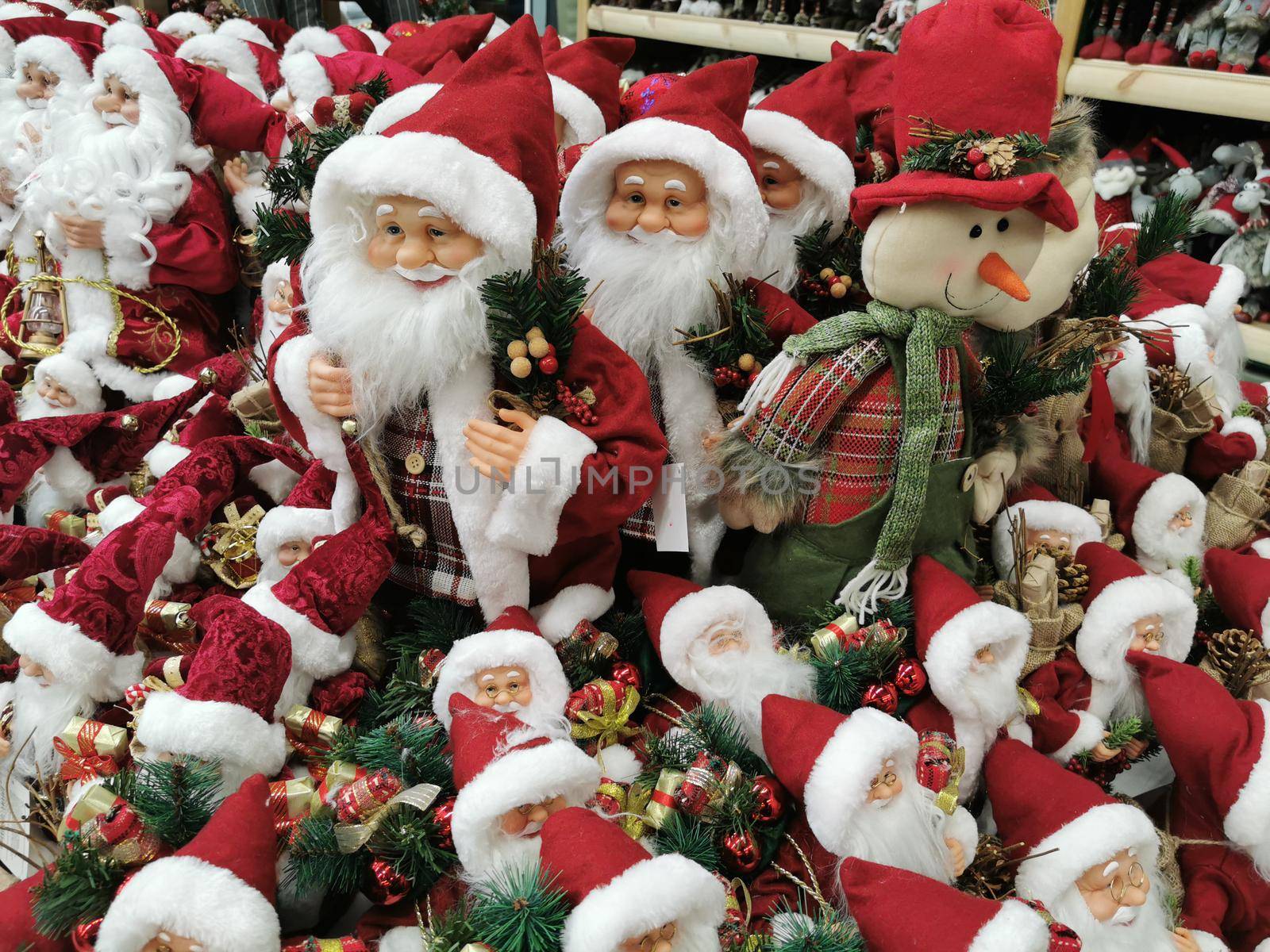 Many Santa Claus toys on a supermarket shelf for sale. Christmas collection in the store. Xmas decorations Manufacturers & suppliers concept. New Year.