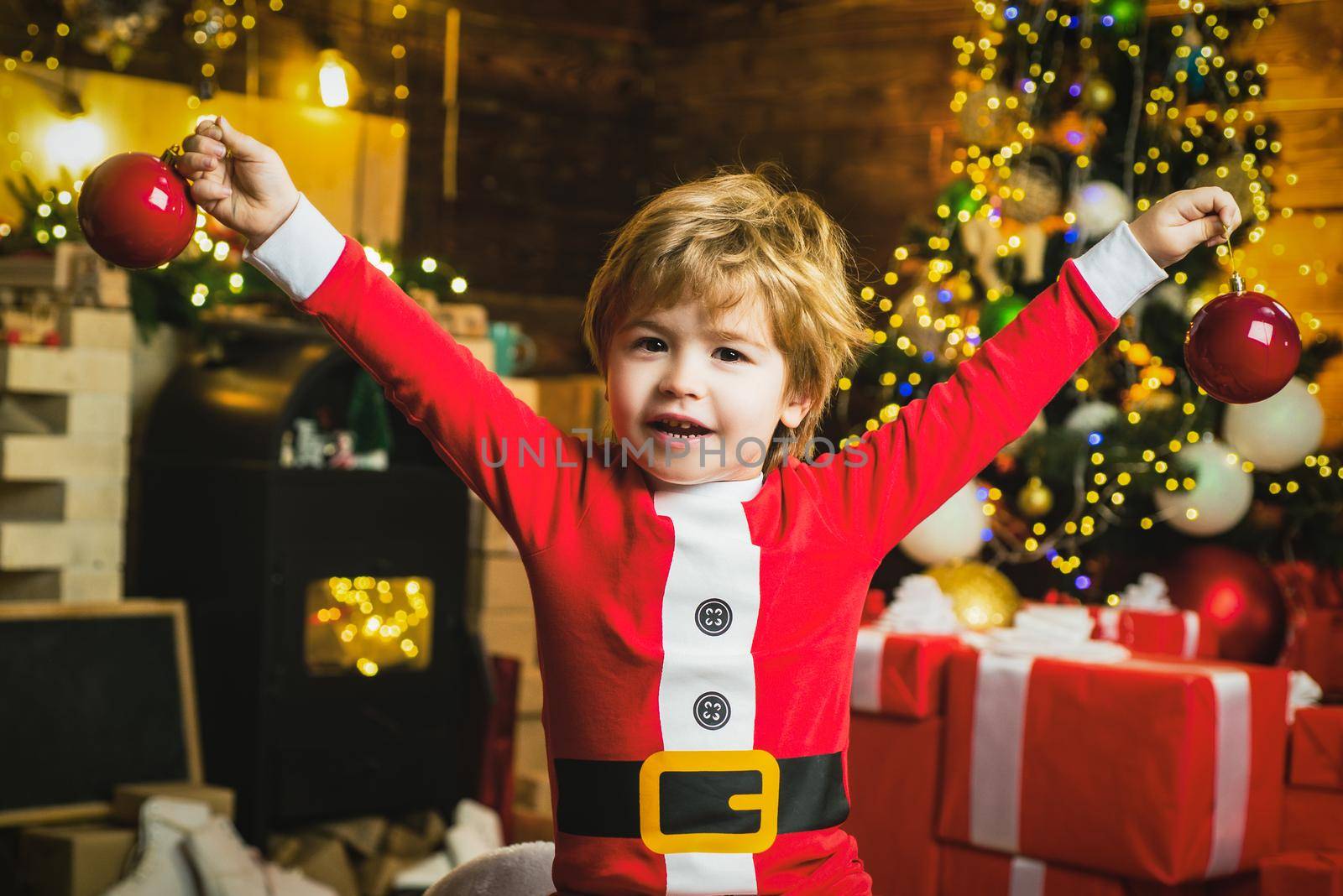 Christmas child dreams. Excited kid boy having fun near Christmas tree. by Tverdokhlib