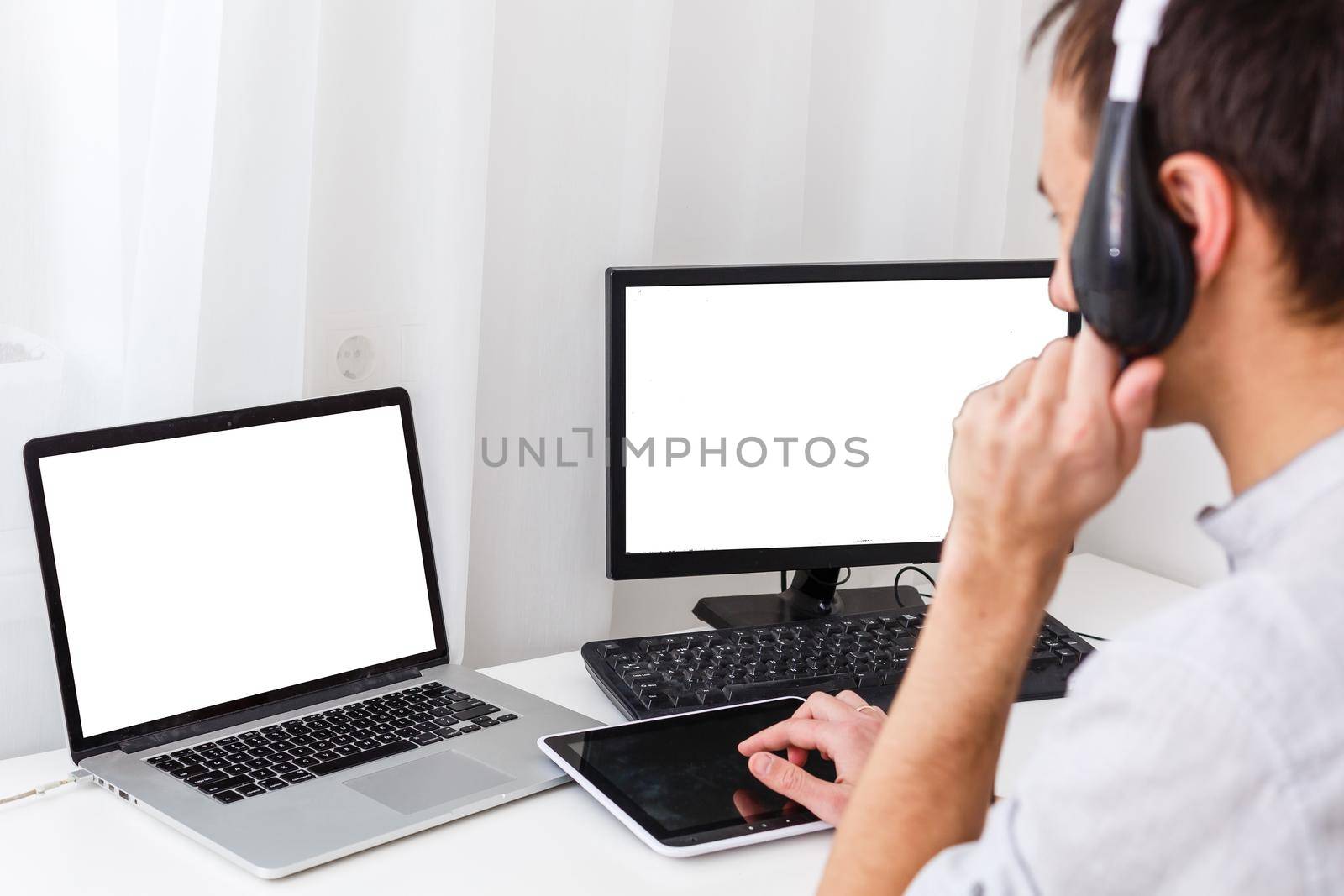 Back view of male person sitting front open laptop computer with blank empty screen for your information or content, modern businessman working in internet