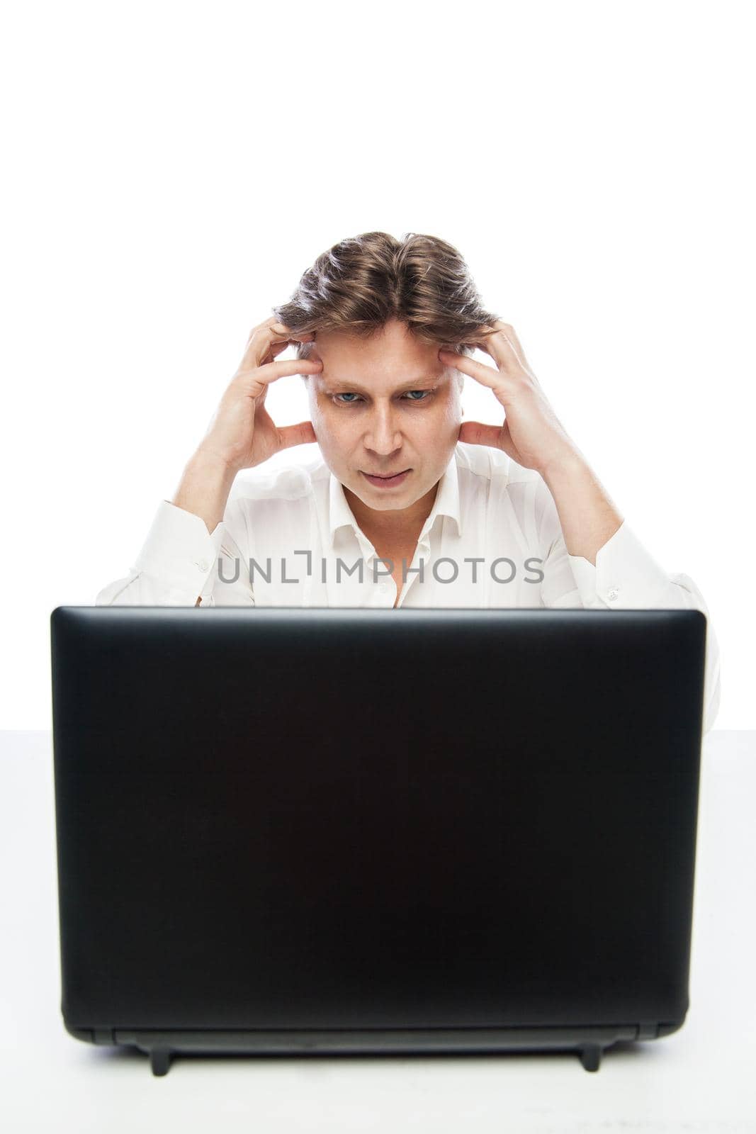 Portrait of thinking young office worker with laptop isolated on white