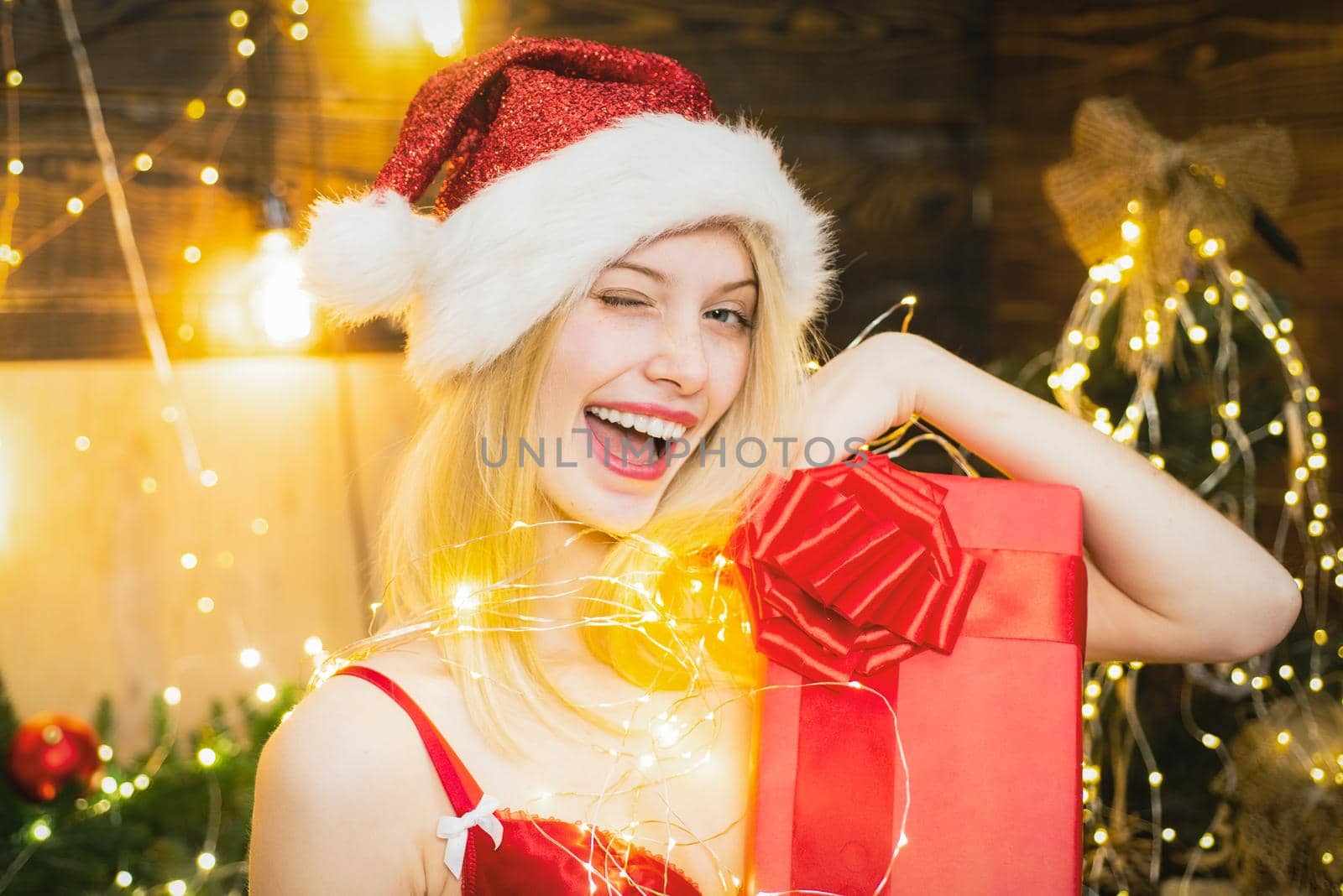 Sexy santa woman at home near christmas tree. Love peace and joy for whole year. Funny girl celebrate new year and merry christmas