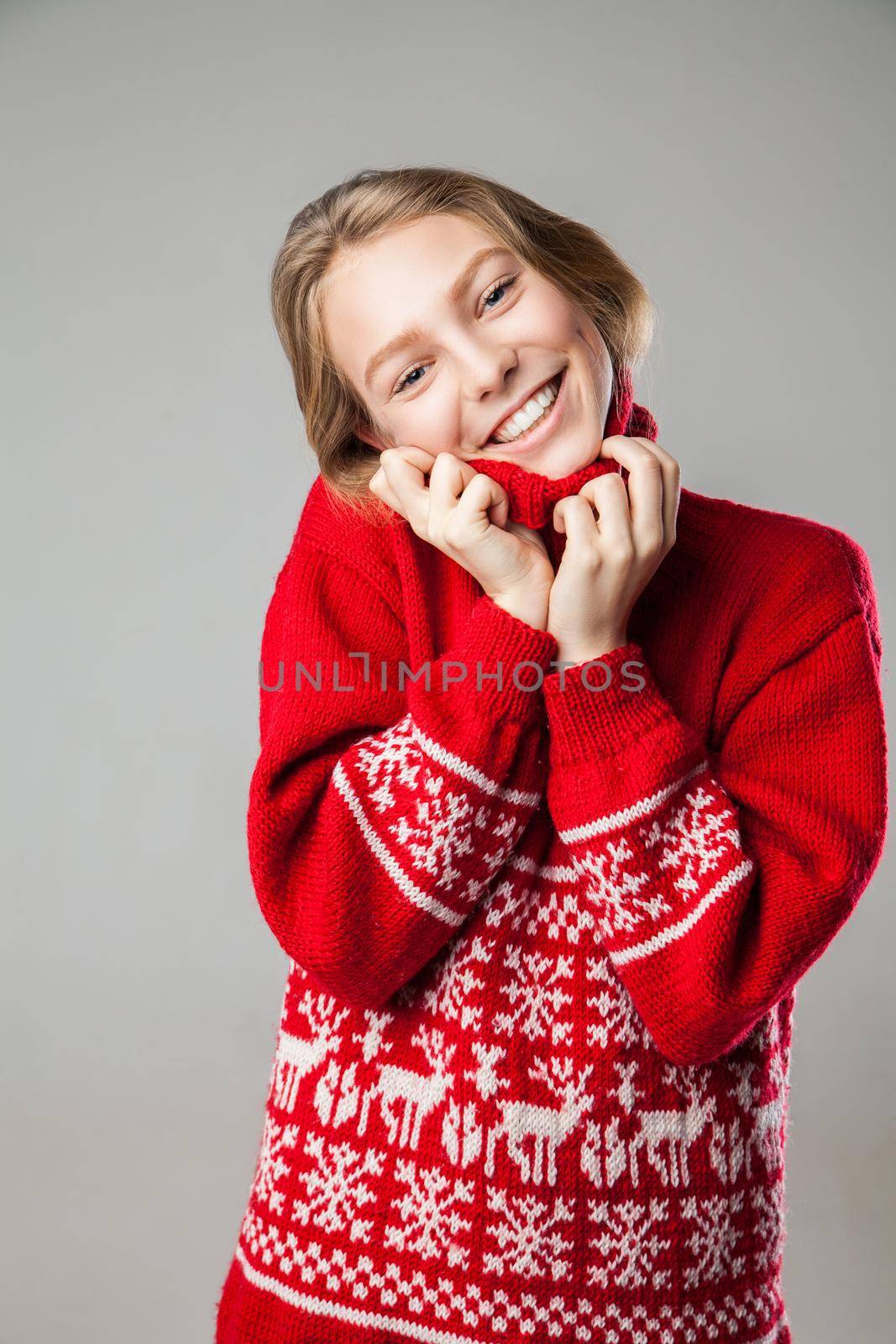 Beautiful young Girl wrapped in a warm knitted warm comfort sweater.