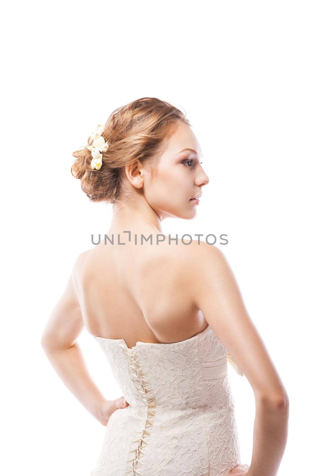 The beautiful young woman posing in a wedding dress. Beauty make-up. Jewellery