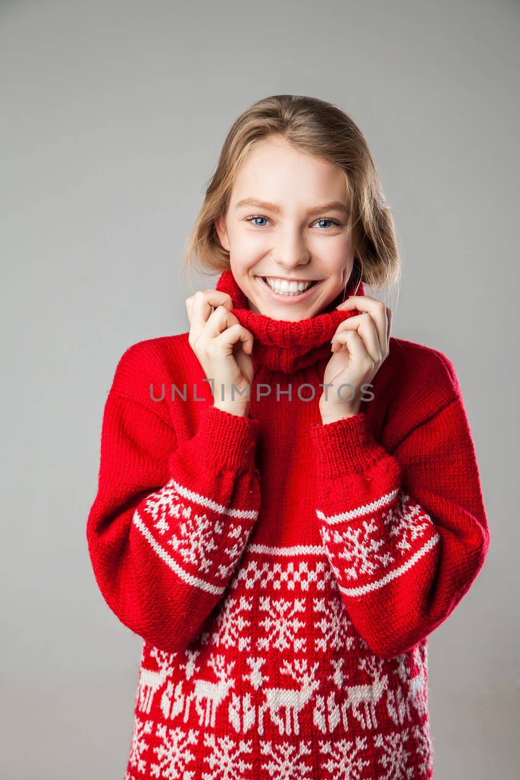 Beautiful young Girl wrapped in a warm knitted warm comfort sweater.