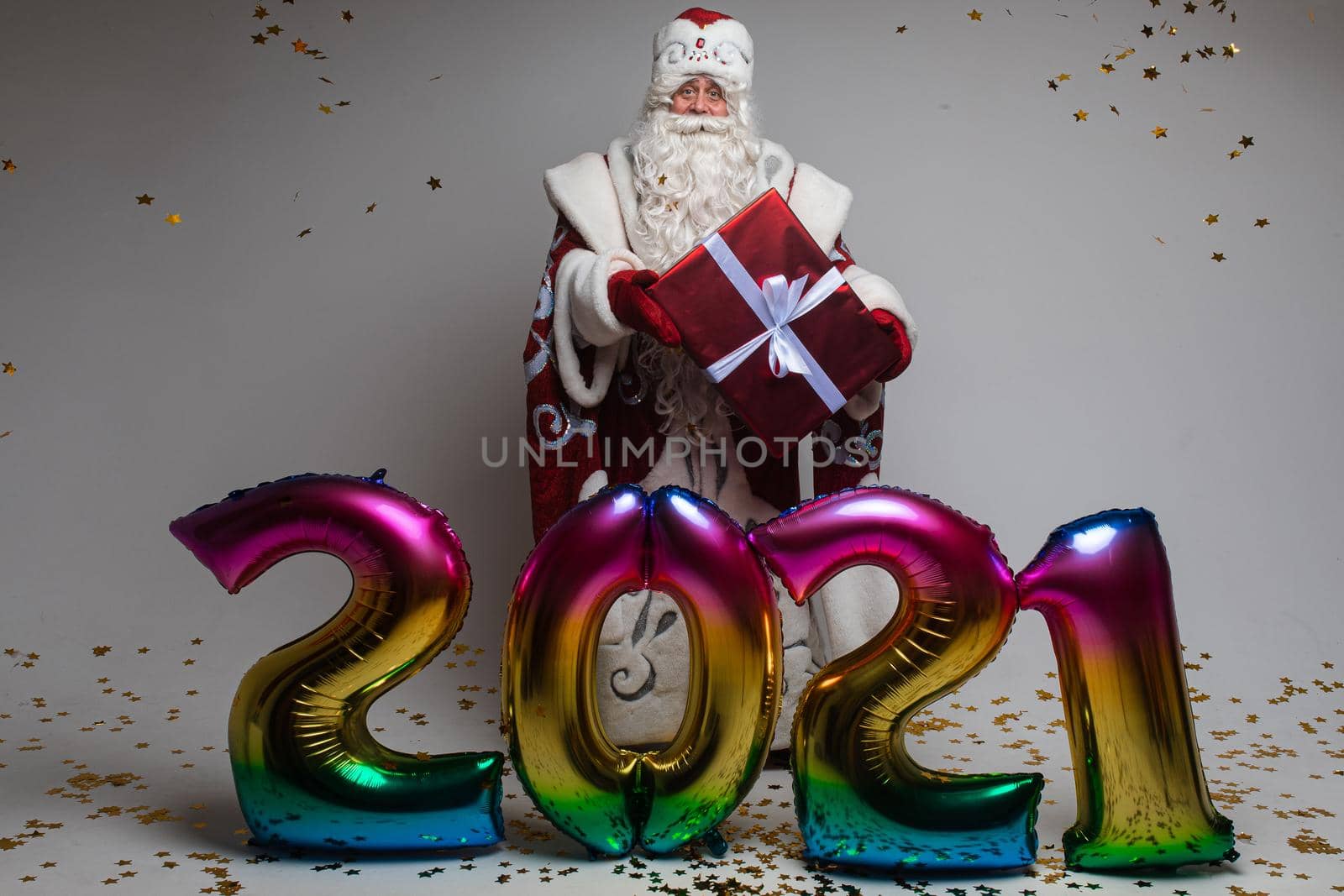 Colourful balloons in shape of 2021 and Santa with gift celebrating xmas and new year. High quality photo