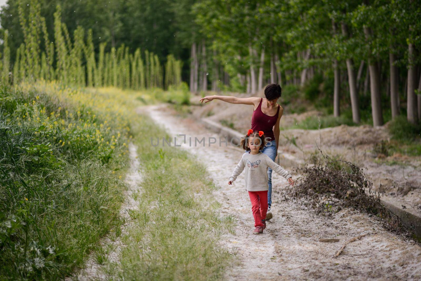 Mother with her little daughter in poppy field by javiindy