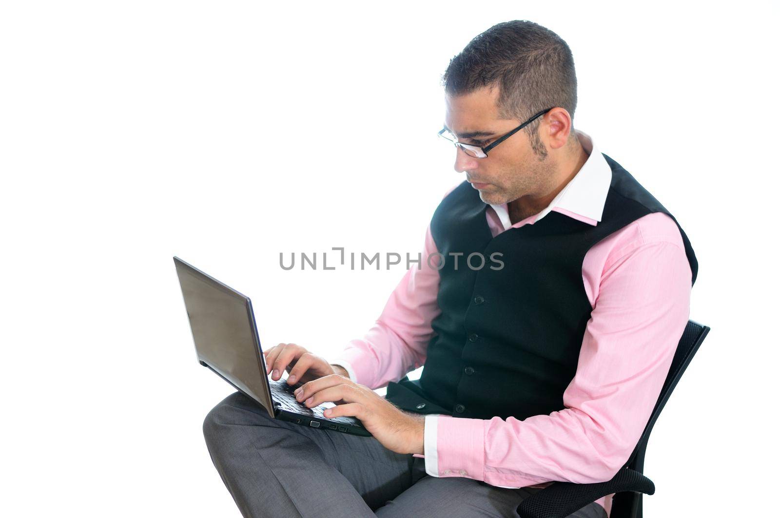 A successful businessman with glasses wearing vest and pink shirt looking at a little computer