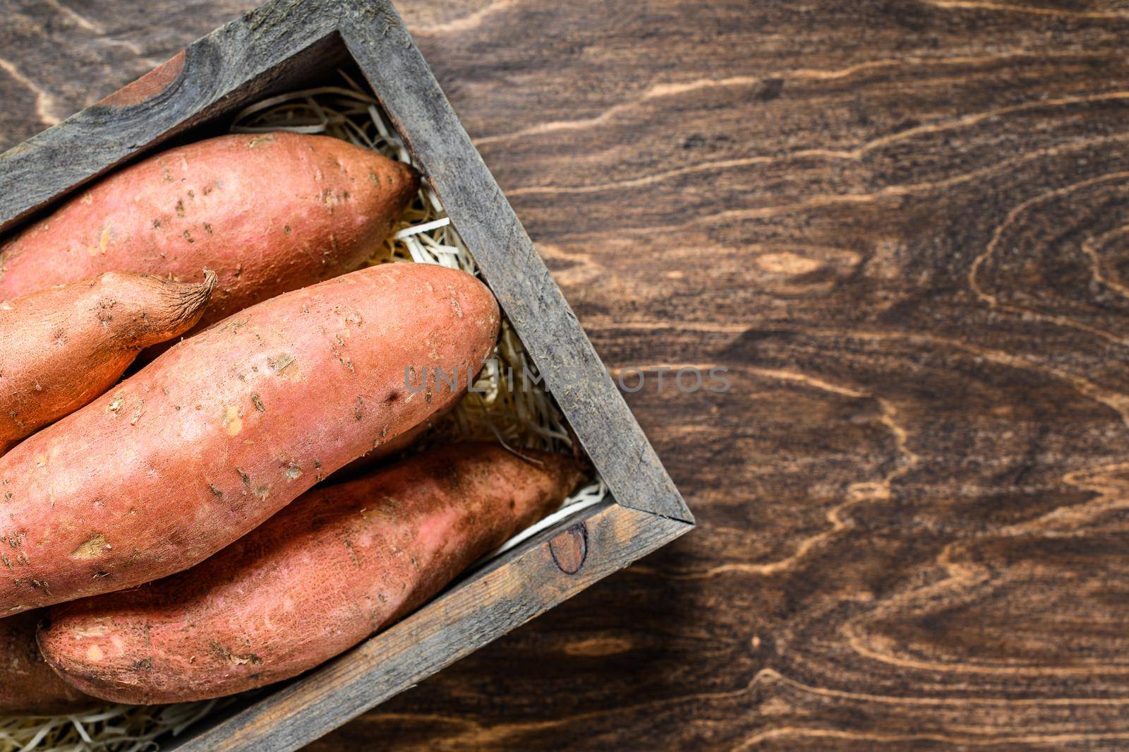 Raw batata Sweet potato on Wooden table. Wooden background. Top view. Copy space by Composter