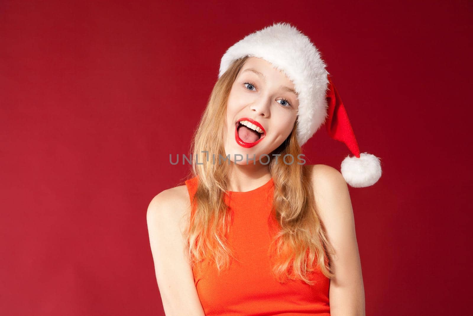 Portrait of beautiful sexy girl wearing santa claus clothes over red background