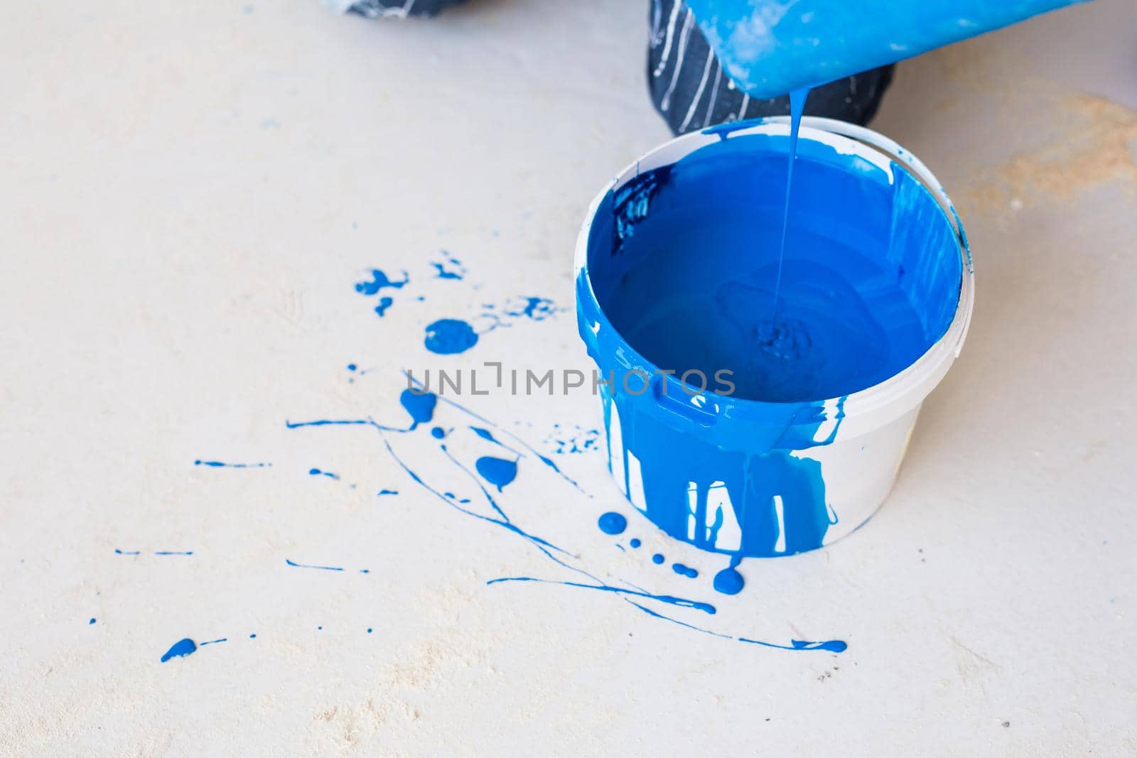 House renovation and redecoration concept - paint bucket on white floor, top view