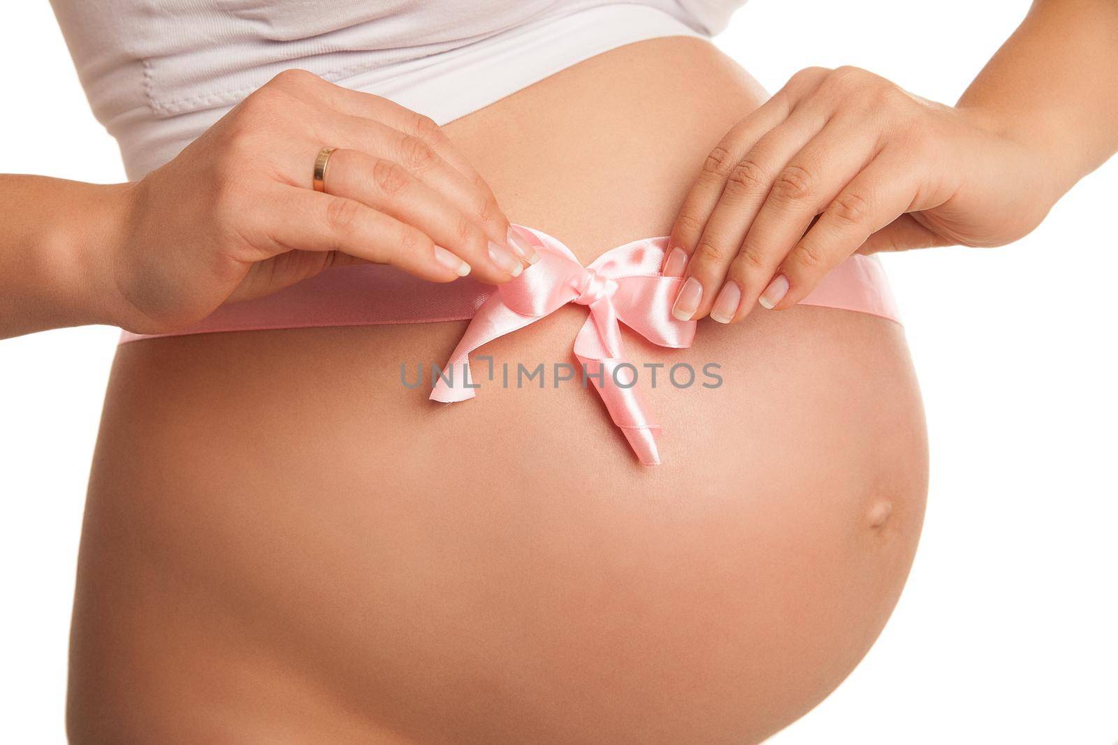 Pregnant woman tummy with pink ribbon over white by Julenochek