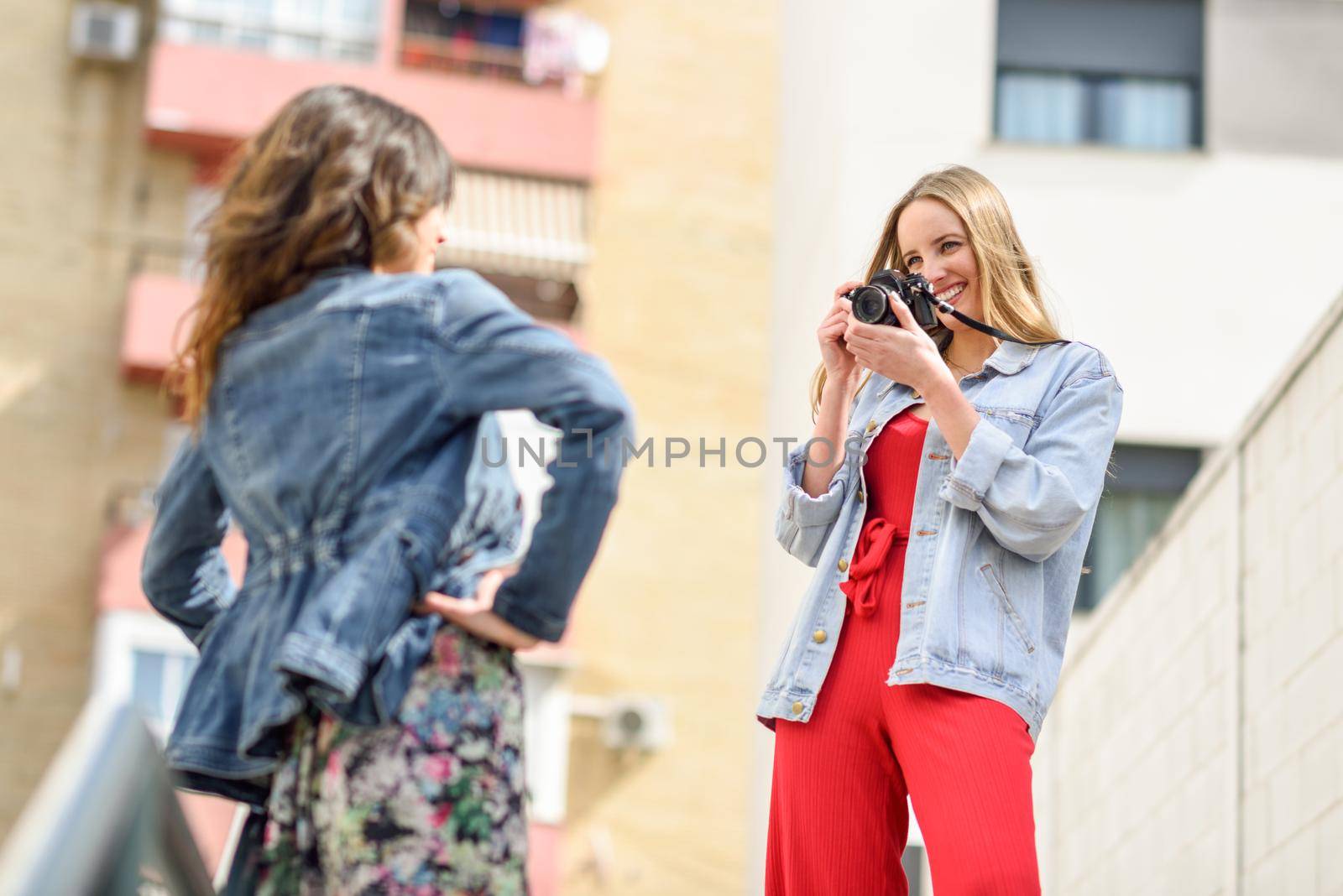 Two young tourist women taking photographs outdoors by javiindy