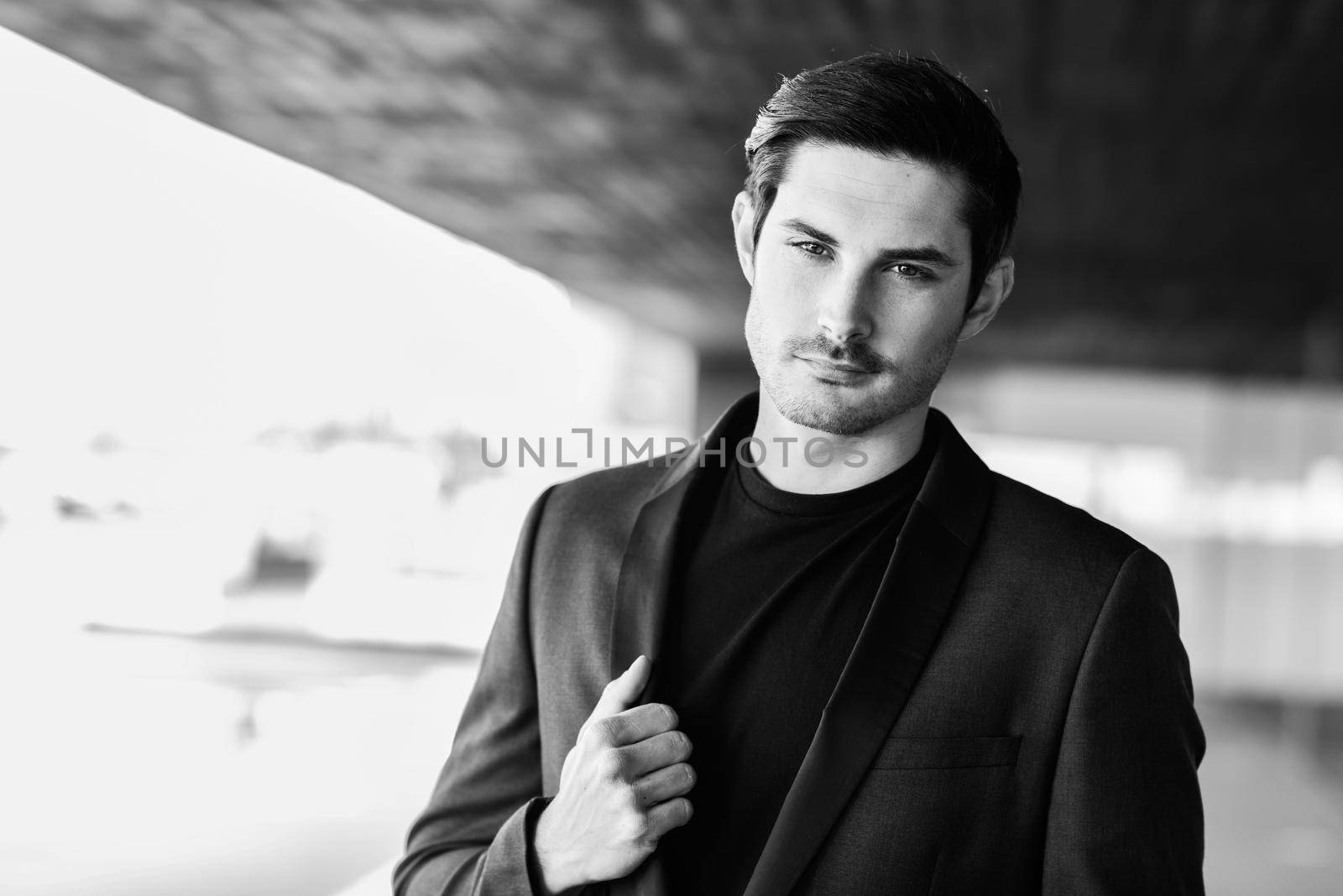 Portrait of an attractive man, model of fashion, wearing modern suit.