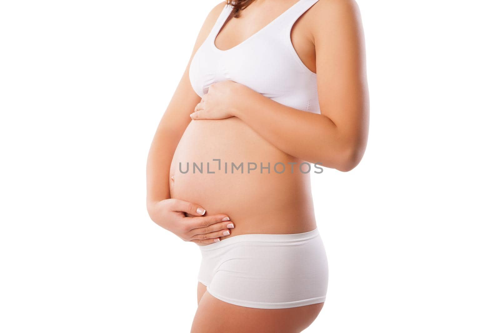 Beautiful belly of young attractive pregnant woman over white background